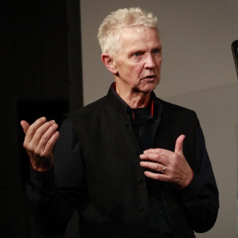 Nigel R. Hughes speaking on stage
